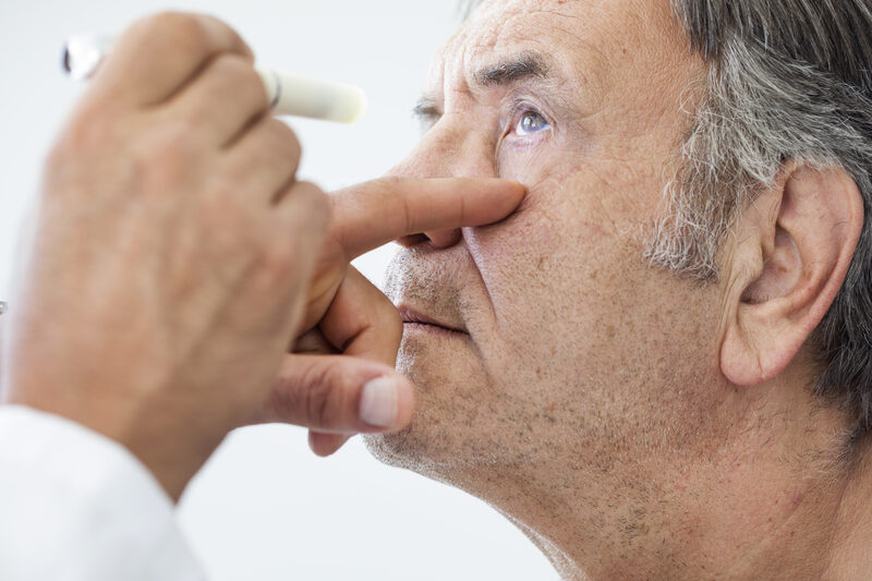 elderly man getting his eye looked at